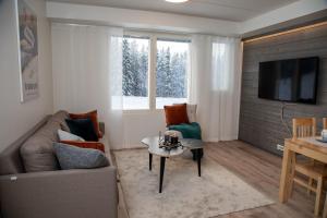 a living room with a couch and a table at Levillenet Skistar Superior apartments in Levi