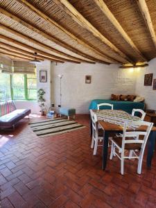 - un salon avec une table, des chaises et un canapé dans l'établissement Cabaña Pimientos, à San Pedro de Atacama