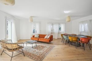 een woonkamer met een bank en een tafel en stoelen bij Maison moderne parisienne in Colombes