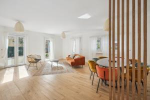 een eetkamer en een woonkamer met een tafel en stoelen bij Maison moderne parisienne in Colombes