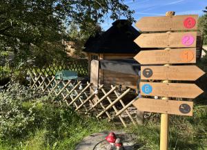 a directional sign in front of a wooden house at KOTAs Accueil Vélo - Chez Flo & Marc in Chouzy-sur-Cisse