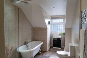 a bathroom with a tub and a toilet and a sink at Spacious home sleeps 13 guests Shirley in Solihull