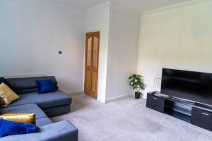 a living room with a couch and a flat screen tv at Spacious home sleeps 13 guests Shirley in Solihull