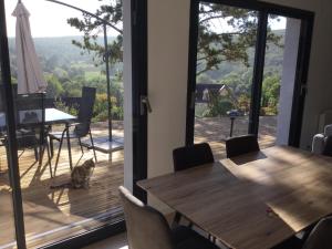 a dining room with a table and a cat sitting on a deck at Savigny view in Savigny-lès-Beaune