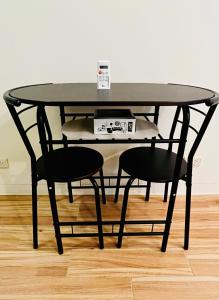 BiñanにあるJFam Suites - Studio and 1Bedroom Units!の黒いテーブルと椅子2脚