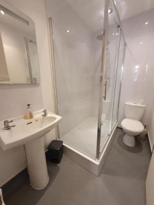 uma casa de banho com um chuveiro, um lavatório e um WC. em 63B Willesden Lane Two Bed Apartment em Londres