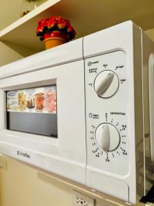a white microwave oven on a shelf at JFam Suites - Studio and 1Bedroom Units! in Biñan