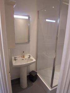 a bathroom with a sink and a shower at 63B Willesden Lane Two Bed Apartment in London