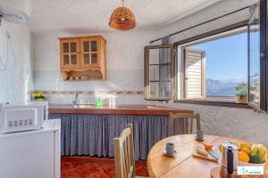 a kitchen with a table and a kitchen with a window at Living Artenara - EARTH Adults Only in Artenara