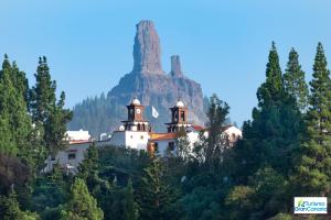 a church on a hill with a mountain in the background at Living Artenara - EARTH Adults Only in Artenara