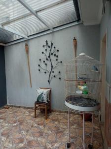a bird cage in a room with a tree on the wall at quarto 05 solteiro aconchegante a 2 km de Alphaville in Barueri +2 photos