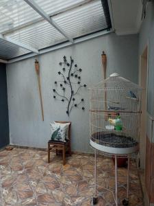 a bird cage in a room with a tree on the wall at quarto 05 solteiro aconchegante a 2 km de Alphaville in Barueri