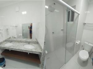 een witte badkamer met 2 wastafels en een douche bij Spazzio DiRoma com Parque incluso! in Caldas Novas