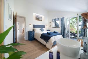 um quarto com uma cama e uma banheira num quarto em Courtyard Cottage em Barnstaple