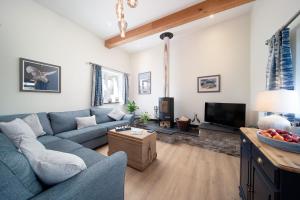 ein Wohnzimmer mit einem blauen Sofa und einem Fernseher in der Unterkunft Courtyard Cottage in Barnstaple