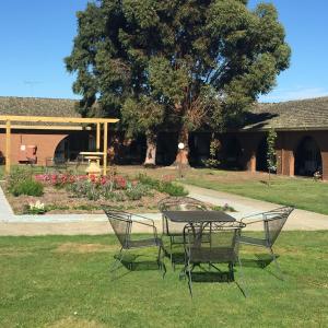 a table and chairs sitting on the grass in a yard at Bell Tower Inn in Ballarat