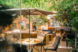 a patio with tables and chairs and an umbrella at Carob Hostel in Amman