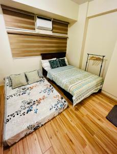 Duas camas num quarto com pisos em madeira em JFam Suites - Studio and 1Bedroom Units! em Biñan