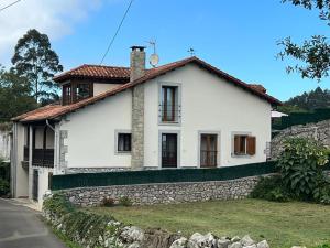 a white house with a stone wall at D´Eloisa in Balmori