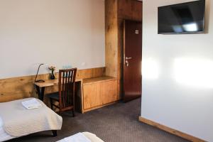 Hotel Regina في رادوم: غرفة بالفندق بها مكتب وسرير وتلفزيون