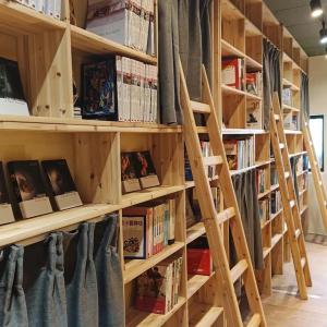 a library with wooden shelves filled with books at Hsinchu Book&Bed in Hsinchu City