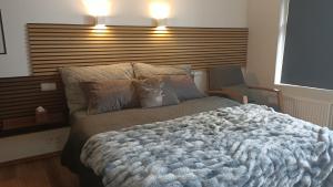 a bedroom with a large bed with a wooden headboard at Ocean View Suite near Sky Lagoon in Reykjavík