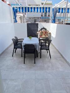 a patio with a table and chairs on a balcony at Dúplex 8, en primera línea de playa in Sanlúcar de Barrameda