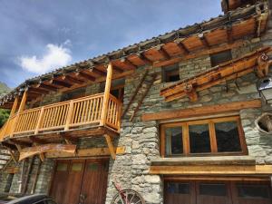 a log cabin with a balcony on the side of it at Chalet Le Grand Méan in Bonneval-sur-Arc