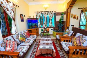 uma sala de estar com um sofá, cadeiras e janelas em Bay Homes 2BHK WT Bathtub Near Rock Beach em Pondicherry