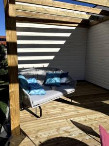 - un banc sur une terrasse avec des oreillers bleus dans l'établissement Pavillon d'Éole, à Berck-sur-Mer