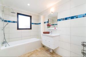 a white bathroom with a tub and a sink at Eden villas in Nathon Bay