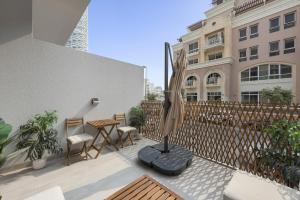 um pátio com uma mesa, cadeiras e uma cerca em VayK - Chic Studio with a Large Terrace in JVC em Dubai