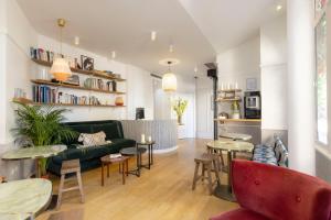 a living room with a couch and tables at Hôtel Emile Le Marais in Paris