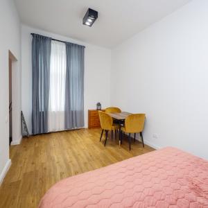 a bedroom with a bed and a table and chairs at Well located cozy place in Lviv