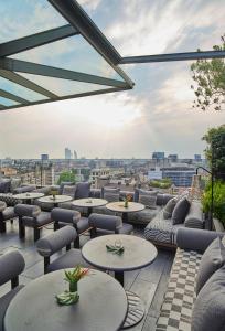 a rooftop patio with tables and chairs and a view at ME Milan Il Duca in Milan