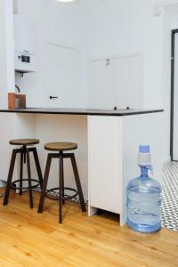 a kitchen counter with two stools and a bottle of water at Well located cozy place in Lviv