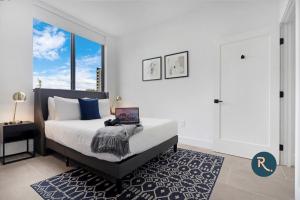 a bedroom with a bed and a large window at Roami at Metro Park in Miami