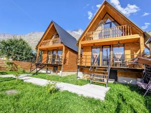 Cottage Caucasus في كازباجي: كابينة خشبية مع شرفة وسطح