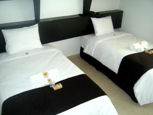 two beds in a hotel room with white sheets at Mochican Palace Hotel in Huanchaco