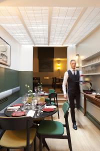 a man is standing in a restaurant with a table at Ninù Roma centro storico in Rome