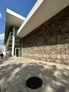 a large building with a stone wall next to a sidewalk at Ninù Roma centro storico in Rome