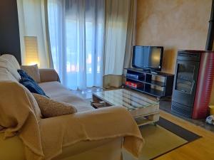 salon z kanapą i telewizorem w obiekcie EL BALCÓN PANORÁMICO DE GREDOS w mieście Mijares