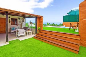 a house with a large deck with a green lawn at La Casa de Arriba in Arucas