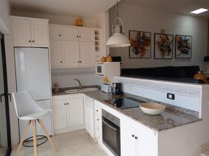a kitchen with white cabinets and a counter top at Apartamento Faro de Sardina in Gáldar