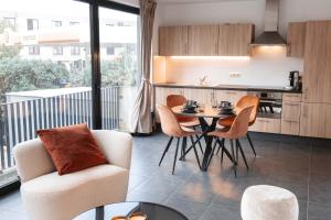 eine Küche und ein Wohnzimmer mit einem Tisch und Stühlen in der Unterkunft K&Y suites 2 ,500m to Brussels airport! in Zaventem