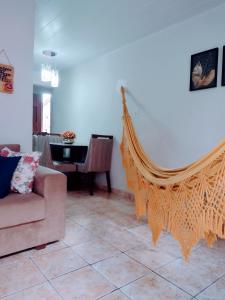 ein Wohnzimmer mit einem Sofa und einer Hängematte in der Unterkunft Casa aconchegante ao lado da Igreja Matriz- Bananeiras-PB in Bananeiras