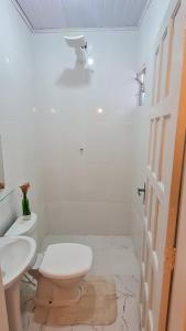 uma casa de banho branca com um WC e um lavatório em Casa Maria Flor em Arraial do Cabo
