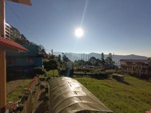 a view of a field with the sun in the sky at Mountain View Passaddhi Comfort Stay in Kalimpong