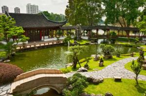 un jardín con un puente y un estanque frente a un edificio en 1BR Marvelous apartment in Singapore! en Singapur