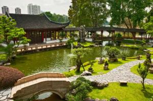 a garden with a bridge and a pond in front of a building at 1BR Marvelous apartment in Singapore! in Singapore
